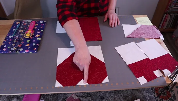 Prepare fabric pieces: Four 1.5-inch background squares, two 5.5-inch background squares, and two 5.5 x 10.5-inch rectangle main heart pieces.