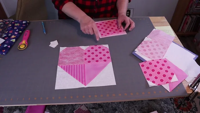Prepare fabric pieces: Four 1.5-inch squares, two 5.5-inch background squares, two 6.5-inch squares for half-square triangles.