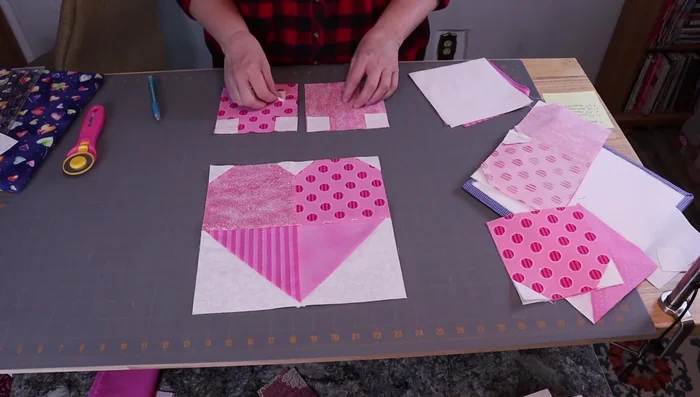 Assemble the top and bottom parts of the heart separately, using the half-square triangles and background squares. Press seams in alternating directions for nesting.