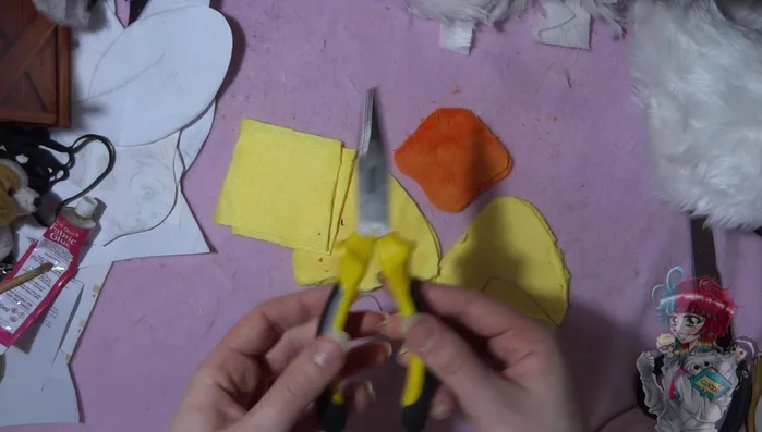 Make the legs and beak. Fold and sew yellow squares for legs, and sew a roundish orange beak.