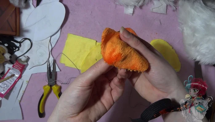 Make the legs and beak. Fold and sew yellow squares for legs, and sew a roundish orange beak.
