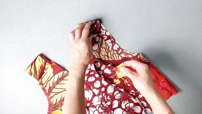 Apply arm binding: Place binding right sides together with armhole, starting about 1.5 inches below shoulder seam. Pin, sew with 3/8 inch seam allowance. Understitch, trim seam allowance, and turn binding to inside. Pin and edgestitch.