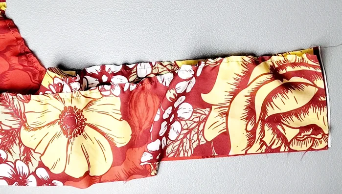 Attach peplum: Place peplum pieces right sides together, sew short edges, serge. Pin peplum to bodice, matching notches. Gather and pin evenly, sew with 5/8 inch seam allowance. Serge seam.