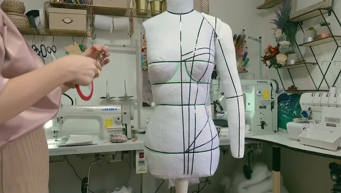 Mark guidelines on the dress form using draping tape. Mark the apex line, side seams, center front, center back, bust, waist, and hip lines.