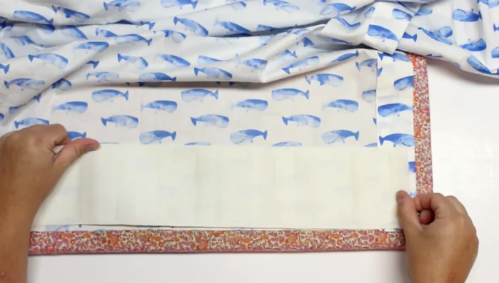 Prepare the bottom hem: Fold the fabric 4 inches and insert the buckram (or interfacing). Sew along the edge.