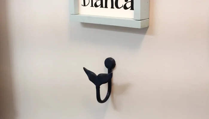 Hang the shower curtain using hooks.