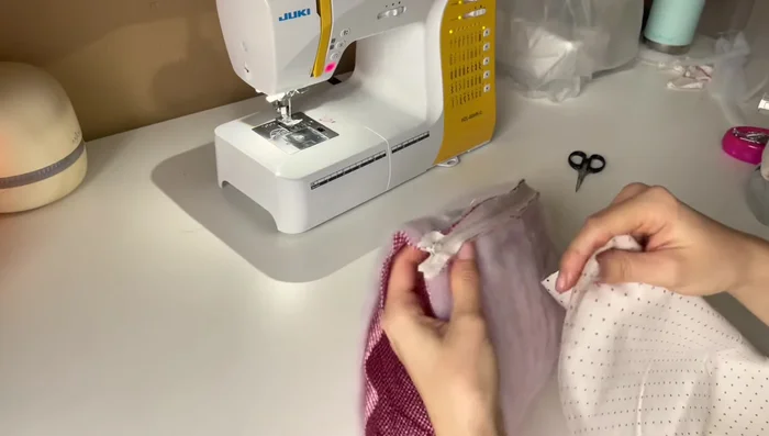 Attach the inner fabric to the zipper. Put the right side of the inner fabric to the wrong side of the zipper. Sew with an open zipper, pausing to close and reopen it to sew past the zipper stops.
