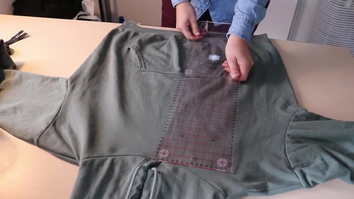 Use a seam ripper to undo the stitches holding the hood in place at the front.