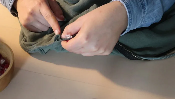 Open up the front seams and add a pleat in the hood on both sides to adjust for the added zipper and maintain a neat fit.