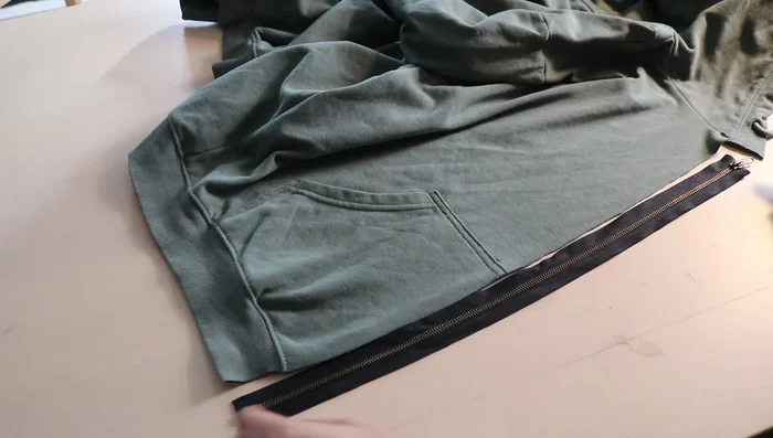 Flip the zipper inside the hoodie and sew a second line of stitching close to the fabric edge to keep the zipper flat.