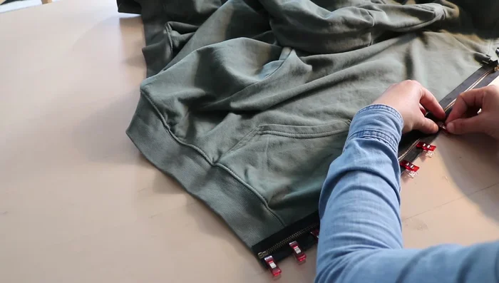 Flip the zipper inside the hoodie and sew a second line of stitching close to the fabric edge to keep the zipper flat.