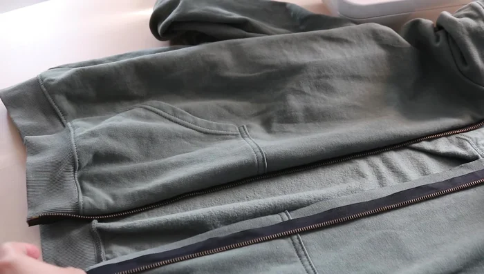 Flip the zipper inside the hoodie and sew a second line of stitching close to the fabric edge to keep the zipper flat.