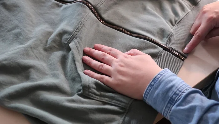 Flip the zipper inside the hoodie and sew a second line of stitching close to the fabric edge to keep the zipper flat.