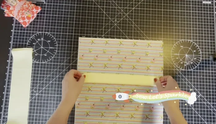 Attach Drawstring Cases to Outer Fabric: Centralize the drawstring cases on top of the outer fabric, leaving about a half-inch gap on each side. Baste the cases close to the edge. Repeat for the other outer fabric piece.