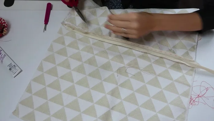 Finish the zipper: Remove basting thread. To shorten the zipper, take several stitches at the bottom where you'll cut and snip off any excess.