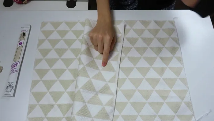 Prepare fabric: Cut fabric to pillow size and serge the outside border. Baste trim facing inward around the entire perimeter of one side of the fabric.