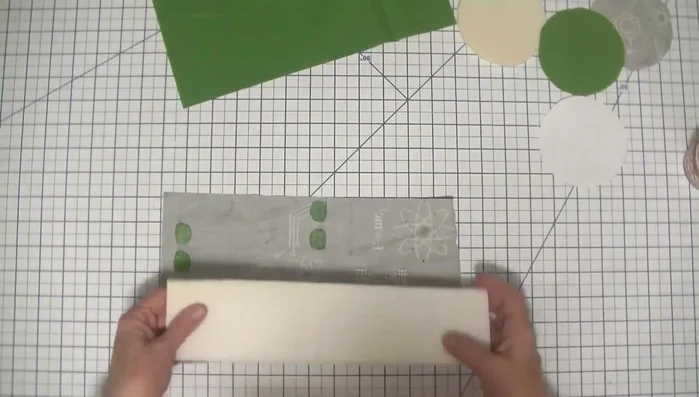 Fuse the fusible foam to the outer fabric and bottom pattern pieces using a damp cloth to ensure proper adhesion.