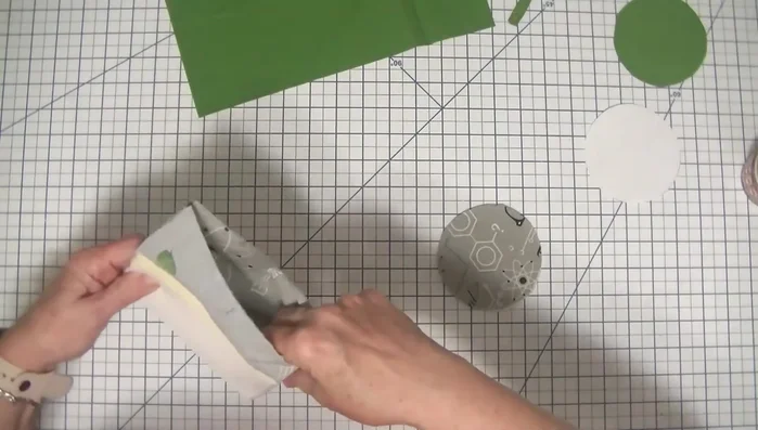 Attach the bottom piece (with fused foam) to the tube, right sides together. Pin or clip to secure. Stitch using a 1/4 inch seam allowance, remembering to leave a 1/2 inch gap for turning. (This gap should be 1 inch from the top).