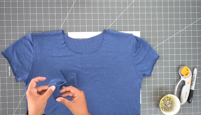 Attach the neckband: Sew the ends of the neckband together to form a loop. Press the neckband in half, wrong sides facing. Pin the neckband to the neckline, matching the center points. Stitch using 1/2 inch seam allowance. Serge and press the seam allowance.