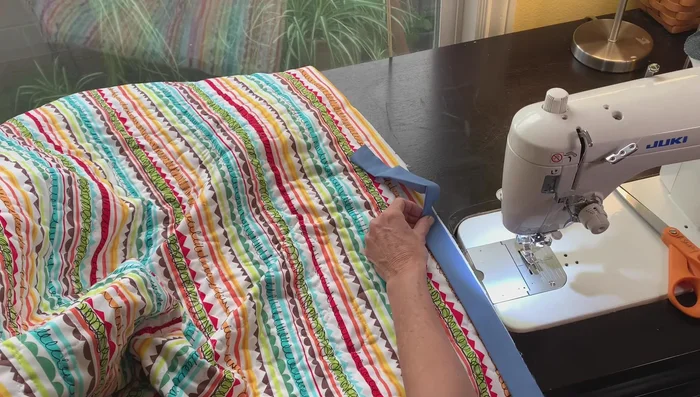 Attach binding to the back: Press the long binding strip in half, wrong sides together. Attach the binding to the back of the quilt using your machine, leaving an opening.