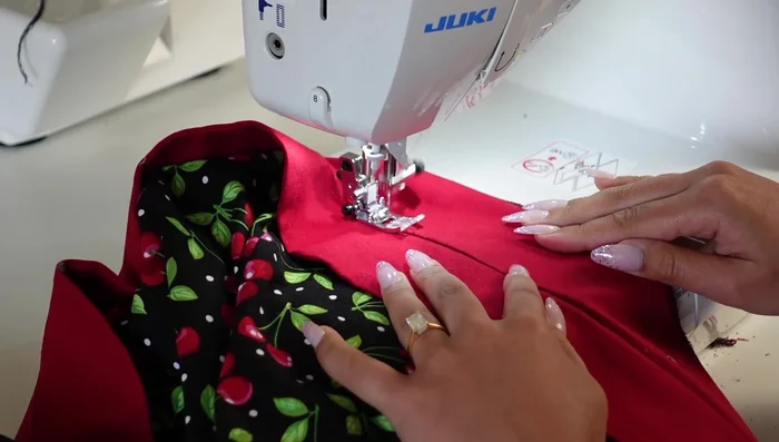 Tack down the facing and neckline band at each vertical seam line to secure. Add a hook and eye closure at the top of the zipper (optional).