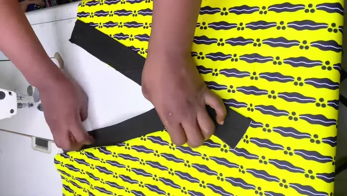 Turn the garment to the back, trim excess fabric if needed, and sew the yellow fabric (or your main fabric) to secure the V-neck.