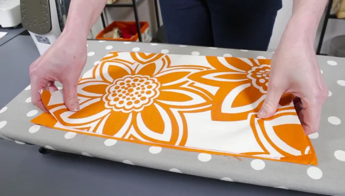 Fuse stabilizer to pockets: Place stabilizer between fabric pieces, centering and aligning with top edges. Iron on high heat for 5 seconds per area on both sides to fuse.