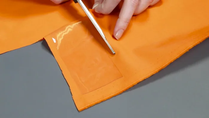 Create label pockets: Place vinyl on top of larger accent fabric piece. Use a marker to draw lines around vinyl. Sew around the vinyl with a zigzag stitch (8mm long, 4mm wide). Cut accent fabric close to stitches.