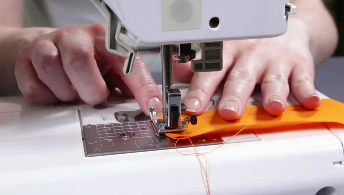 Create ribbon loop: Cut a 12in piece of bias tape, fold ends, and sew. Fold in half, center on the top back, and sew.