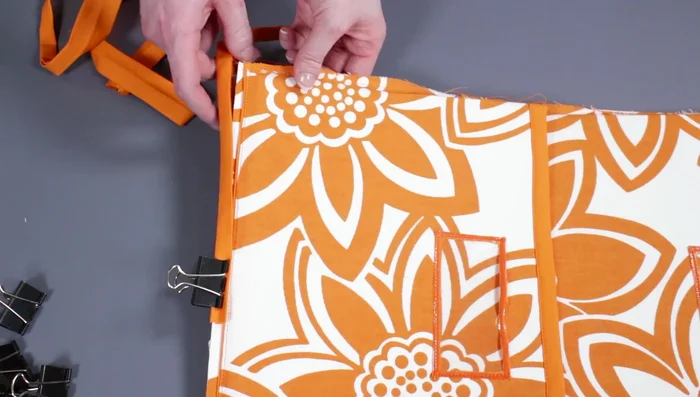 Attach trim: Clip on bias tape trim, adjusting as needed, and sew along all sides, creating 45° angles at corners.