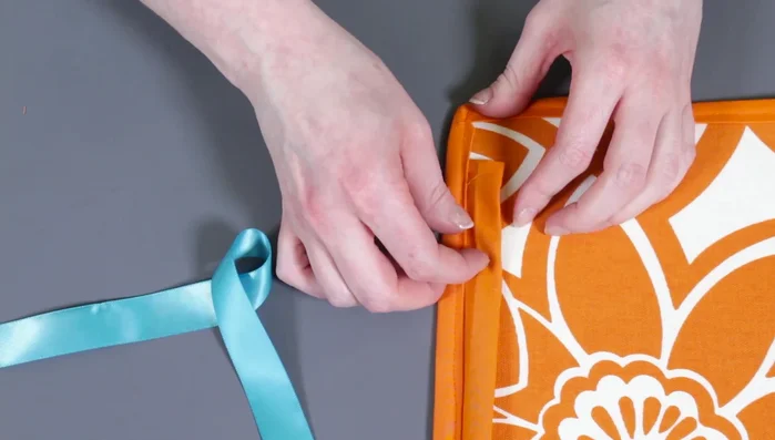 Insert ribbon: Pull ribbon through the top tube, adjust length, sew ends together, and slide seam into tube.