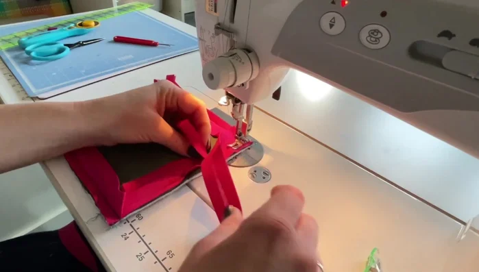 Finish the binding. Continue sewing the binding around the pot holder. At the final corner, overlap the ends, trim excess, and fold to create a clean finish. Backstitch to secure.