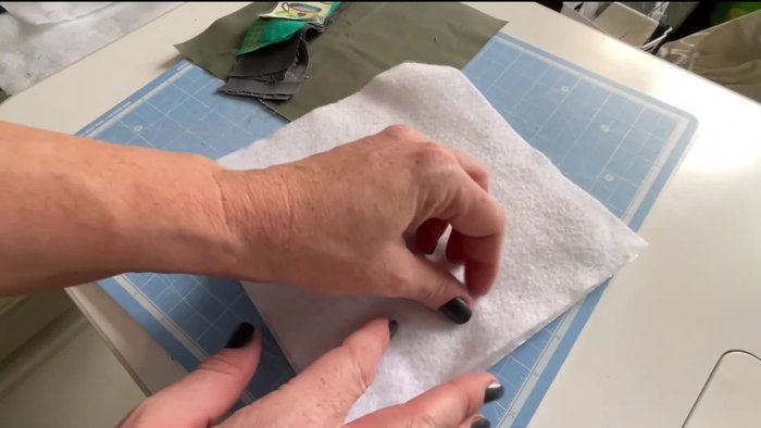 Prepare the center piece. Choose a small scrap of fabric (approximately 2 inches wide) for the center of your pot holder.