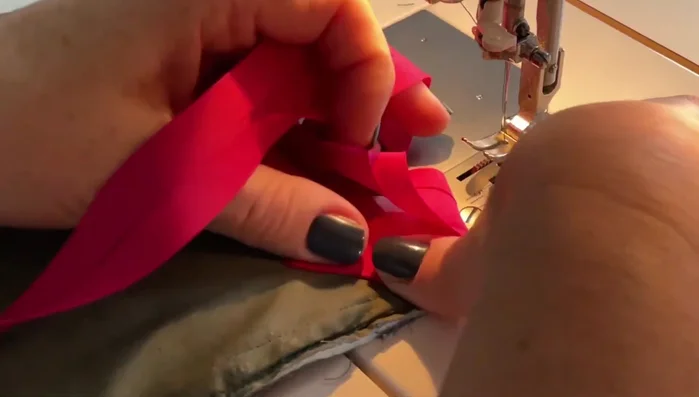 Finish the binding. Continue sewing the binding around the pot holder. At the final corner, overlap the ends, trim excess, and fold to create a clean finish. Backstitch to secure.