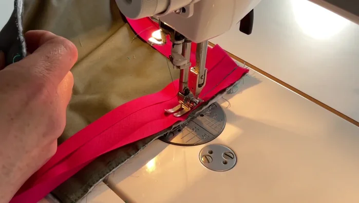 Finish the binding. Continue sewing the binding around the pot holder. At the final corner, overlap the ends, trim excess, and fold to create a clean finish. Backstitch to secure.