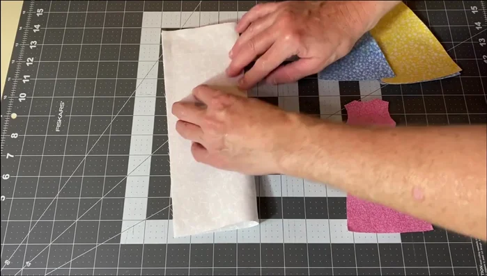 Assemble the Dresses: Place one dress appliqué in the center of each 8x10.5 inch background fabric rectangle. Peel the backing paper from the appliqué and iron it to the fabric.