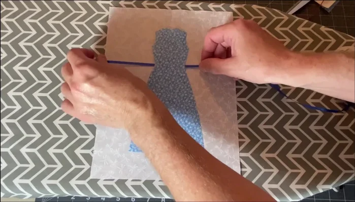 Add Embellishments (Optional): Add ribbon belts, aprons, or other embellishments before ironing the dress completely to the background fabric.