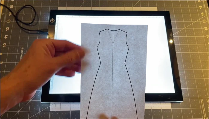 Prepare the Dress Appliqués: Trace the dress pattern onto the paper side of the fabric adhesive, leaving extra fabric around the lines. Cut out the appliqués.