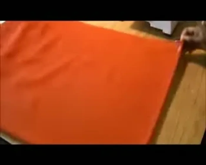 Fold the fabric repeatedly: Continue folding the fabric over itself until it resembles a triangle shape.