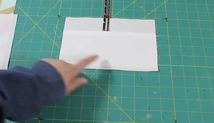 Attach the pocket to the lining: Position the pocket piece on one lining piece, 1.5 inches from the top. Pin and sew in place. Trim any excess fabric.