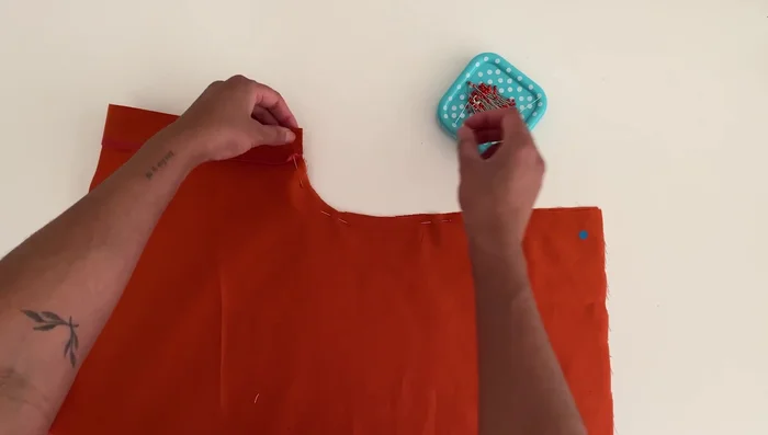 Sew the side seams: Place the top right sides together, pin along the sleeve and side seam, and sew using a 3/8 inch or 1 cm seam allowance. Overlock the seams.