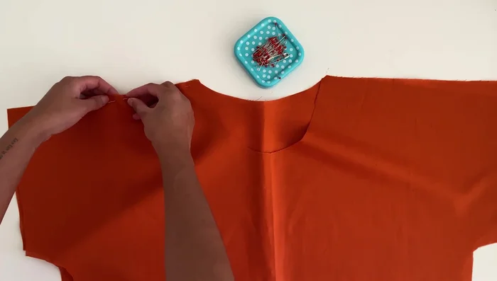 Sew the shoulders: Place the two top pieces together with right sides facing, align the shoulders, and pin. Sew along both shoulders using a 3/8 inch or 1 cm seam allowance. Overlock the seams for a clean finish.