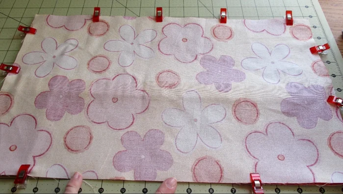 Stitch all around with a 1/2 inch seam allowance, leaving a space at the bottom for turning. When stitching near the elastic loops, pull the main fabric over to match edges before stitching.