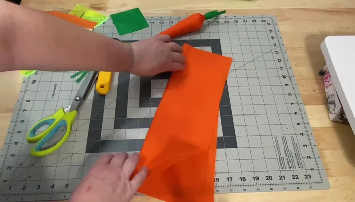 Prepare fabric: Fold fabric in half, ensuring enough fabric to fit your chosen Dresden ruler. You can use solid fabric or create a scrappy version by sewing together various orange scraps.