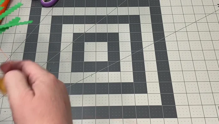 Attach leaves: Insert the leaf clusters into the top of the carrot and secure with additional hand stitching.