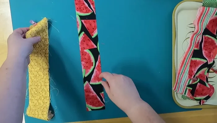 Stitch the center strips: Stitch along both sides of the center strips to secure them to the batting. Use neutral thread that complements both fabric sides.