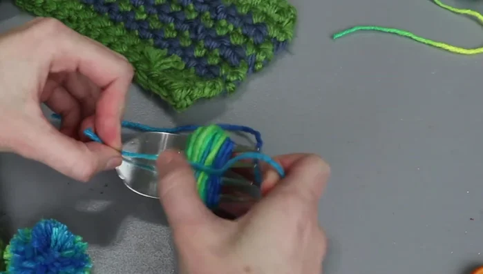 Slide the wrapped yarn off the fork, pull the knot tight, and tie a second knot.