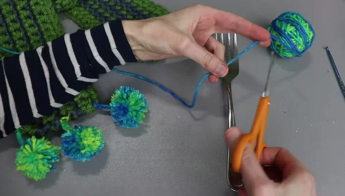 Wrap the yarn around the tines of a serving fork multiple times (35-40 times for desired thickness).