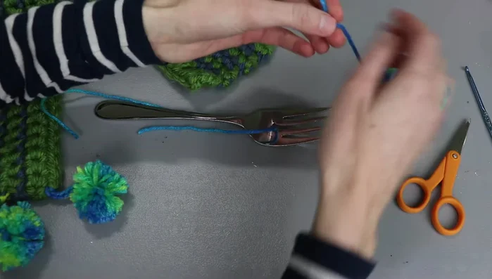 Wrap the yarn around the tines of a serving fork multiple times (35-40 times for desired thickness).