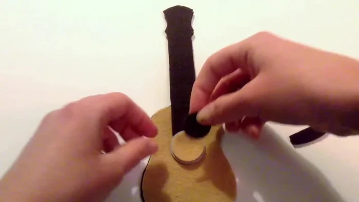 Glue the seven white strips and four small white circles onto the dark brown piece.